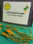Sigma Kappa Delta sign with green & gold tassels