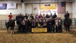 group of equine students in arena with banner, award ribbons & 2匹马