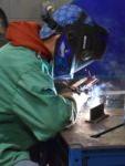 student welding and wearing protective equipment