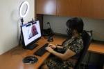 一位女士坐在办公桌前用电脑试用职业服务中心的面试设备