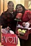 2 people smiling & holding Valentine's Day gifts