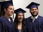 3个面带微笑的毕业生，头戴帽子，身穿长袍