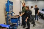 college instructor Paul Ericson showing high school student how to use welding simulator
